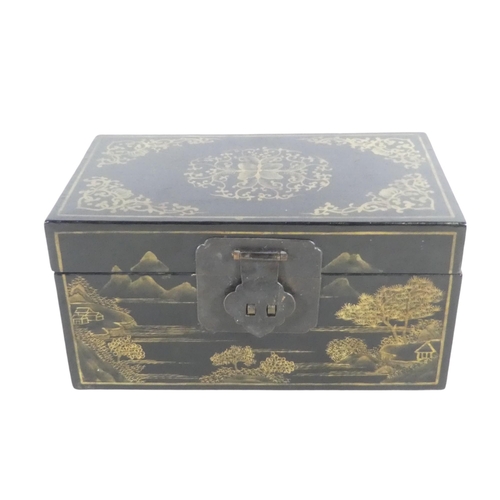 335 - A 20th century black lacquer chinoiserie box - of rectangular form and decorated with landscape scen... 