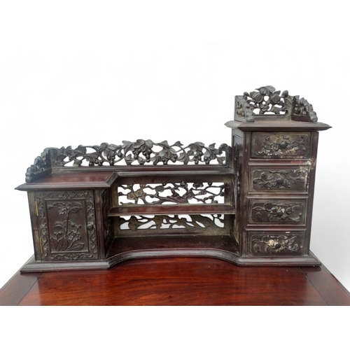 340 - An early 20th century oriental carved hardwood desk - of asymmetrical form incorporating pierced pan... 