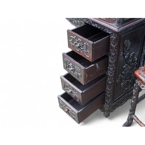 340 - An early 20th century oriental carved hardwood desk - of asymmetrical form incorporating pierced pan... 