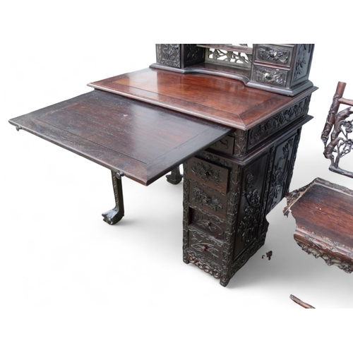 340 - An early 20th century oriental carved hardwood desk - of asymmetrical form incorporating pierced pan... 