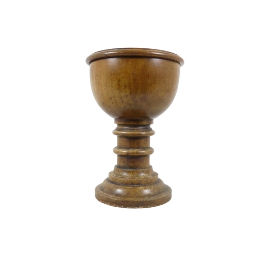 42 - A late 19th century turned walnut font - of chalice form with a copper lined cistern, 31cm high.