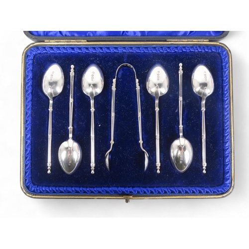 498 - A boxed set of silver tea spoons - Birmingham 1908, together with a pair of sugar nips, 90g.