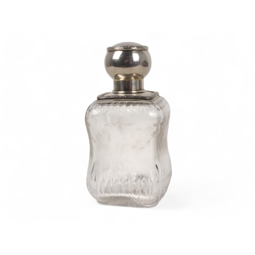 499 - A continental white metal mounted glass perfume bottle - square of a waisted form and etched with fl... 