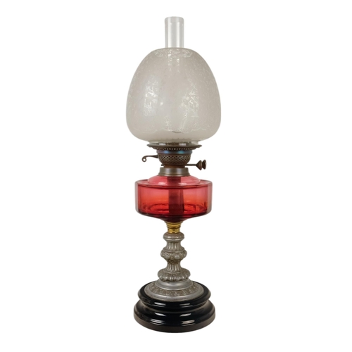 51 - A late 19th century oil lamp - with ruby glass reservoir and fluted baluster support and circular ba... 