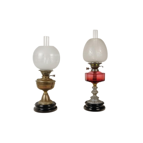 51 - A late 19th century oil lamp - with ruby glass reservoir and fluted baluster support and circular ba... 