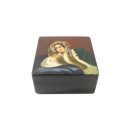 55 - A 20th century Russian papier mache box - the hinged cover decorated with a young woman, signed lowe... 