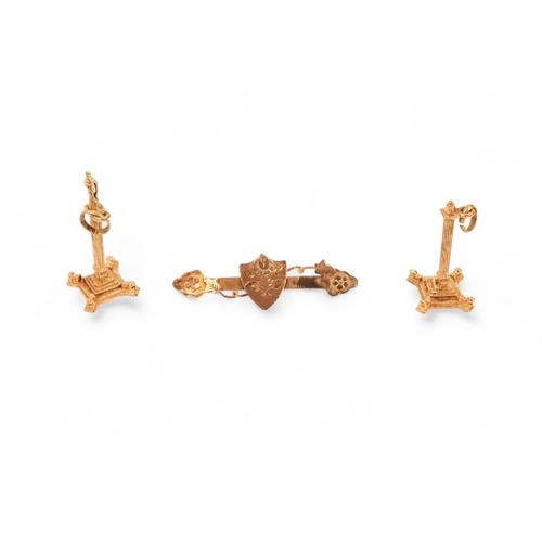 576 - A pair of 9ct gold charms - modelled as columns, together with three further charms, a pendant, a br... 