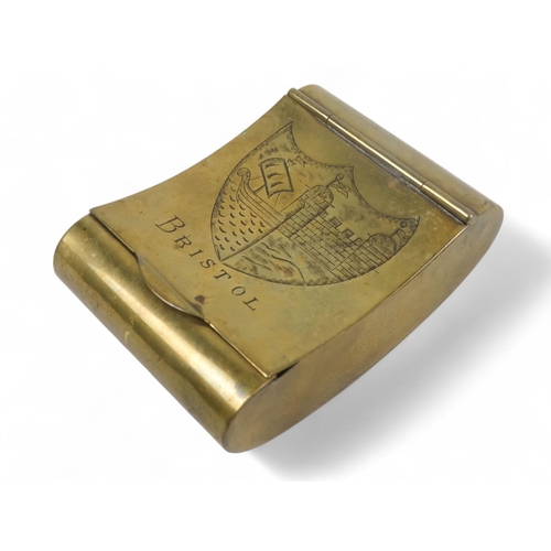 6 - A 19th century brass tobacco box - of curved form and engraved with Bristol armorial, 7cm wide.