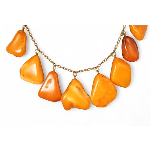 613 - An amber necklace on a white metal chain - with nine polished butterscotch amber drops, together wit... 