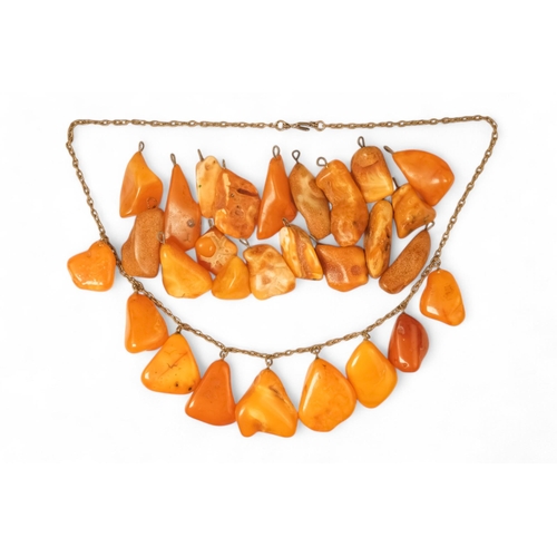 613 - An amber necklace on a white metal chain - with nine polished butterscotch amber drops, together wit... 