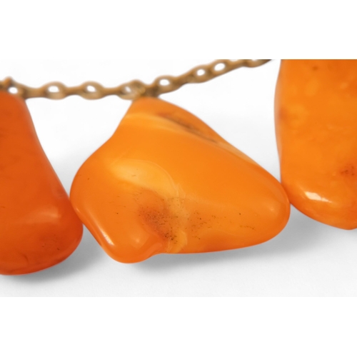 613 - An amber necklace on a white metal chain - with nine polished butterscotch amber drops, together wit... 