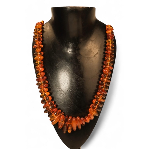 614 - A string of amber beads - length 50cm, together with a further string of amber beads.