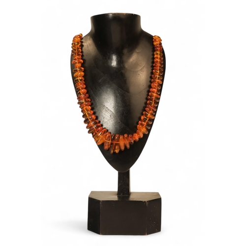 614 - A string of amber beads - length 50cm, together with a further string of amber beads.