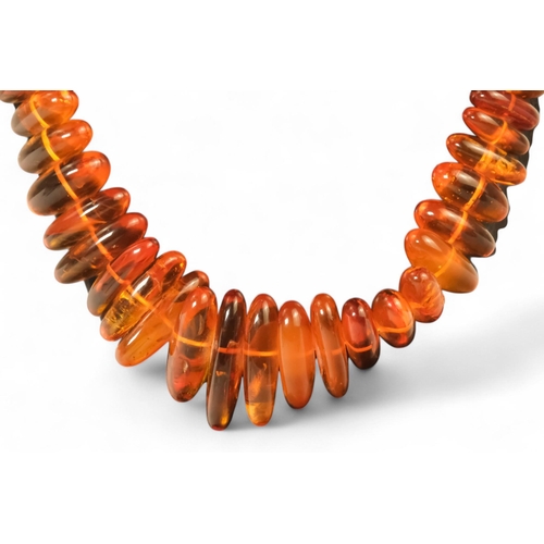 614 - A string of amber beads - length 50cm, together with a further string of amber beads.