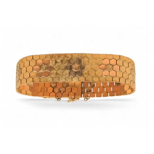 617 - A 9ct gold bracelet - of belt form constructed of articulated hexagons, 43.6g.