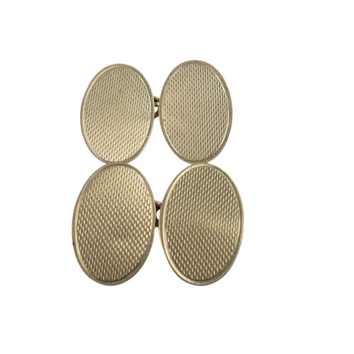 624 - A pair of 9ct gold cuff links - oval with an engine turned finish, 4.1g.