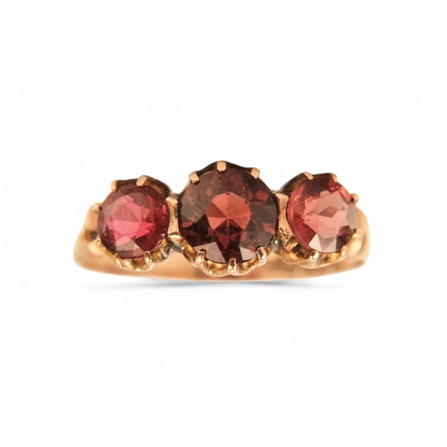 631 - A 9ct gold three stone garnet ring - claw set, size N, together with two further dress rings, 5.8g. ... 