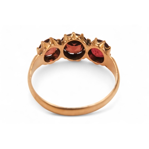 631 - A 9ct gold three stone garnet ring - claw set, size N, together with two further dress rings, 5.8g. ... 