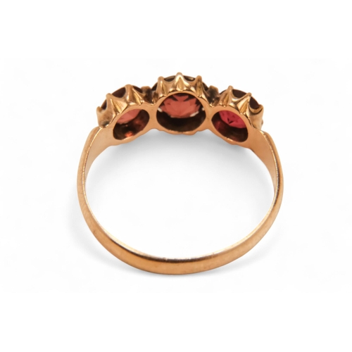 631 - A 9ct gold three stone garnet ring - claw set, size N, together with two further dress rings, 5.8g. ... 