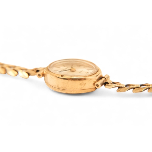 704 - A ladies 9ct gold cocktail watch - oval with a cream dial set out in baton numerals, 10.2g all in, t... 