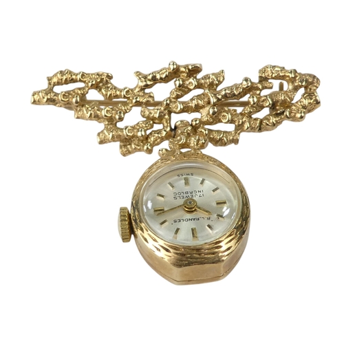 705 - A 9ct ladies fob watch - suspended from a bark effect bar, the silvered dial set out with baton nume... 