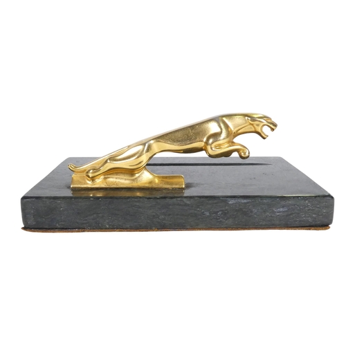 75 - A marble pen tray - mounted with a leaping Jaguar, 18cm wide.