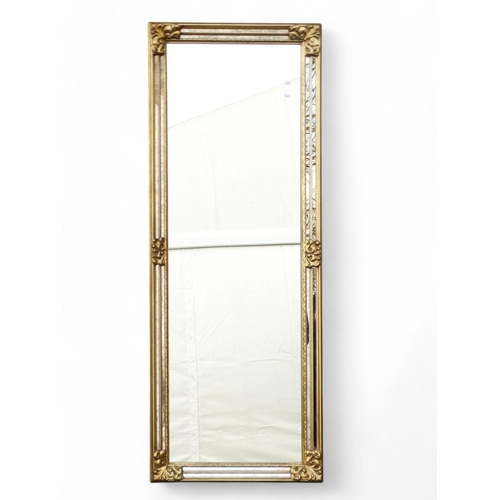 903 - A 20th century gilt framed rectangular wall mirror - the frame incorporating margin plates, 163 x 62... 