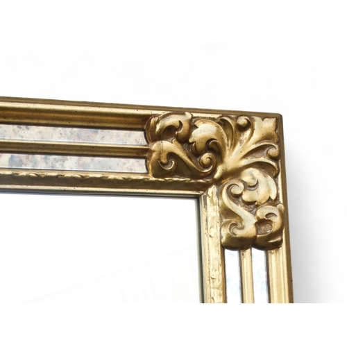 903 - A 20th century gilt framed rectangular wall mirror - the frame incorporating margin plates, 163 x 62... 