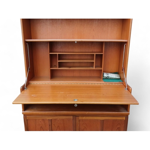 906 - A vintage teak secretaire bookcase in the manner of Ercol - with an arrangement of three shelves abo... 