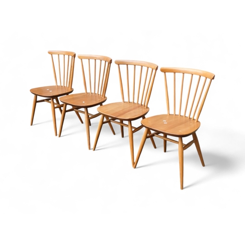 911 - A set of four Ercol beech and elm dining chairs - model 391 with spindle rail back and legs joined b... 