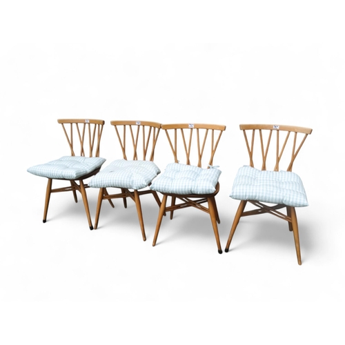 912 - A set of four Ercol beech and elm 'Candlestick' dining chairs - model 376, with labels verso. (4)