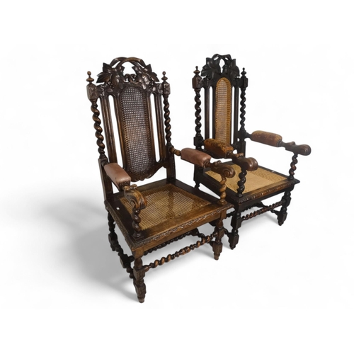 923 - A pair of 17th century style oak open arm chairs - with cane backs flanked by spiral turned supports... 