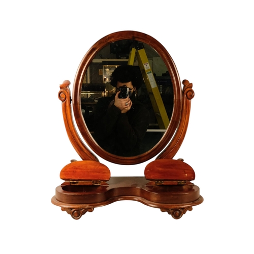 933 - A Victorian mahogany toilet mirror - the oval plate between curved supports, the base incorporating ... 