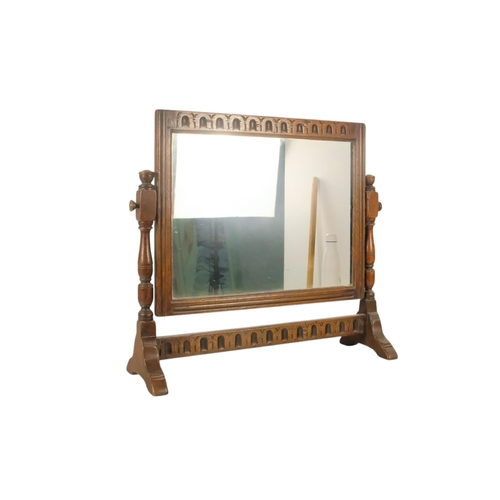 934 - A 17th century style oak toilet mirror - with a rectangular plate and fluted carving between turned ... 