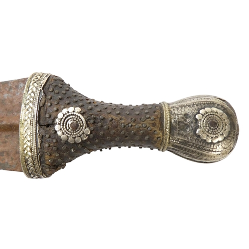 95 - A Middle Eastern Khanjar - the hardwood handle with copper studs and white metal fittings, the curve... 