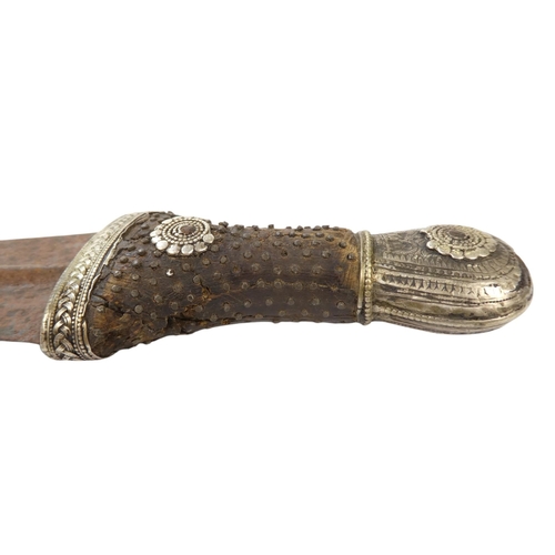 95 - A Middle Eastern Khanjar - the hardwood handle with copper studs and white metal fittings, the curve... 