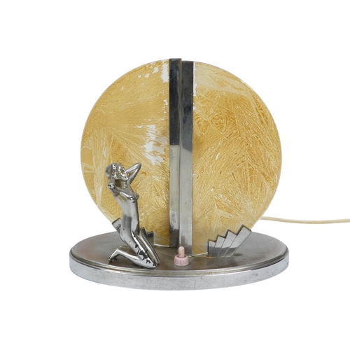 26 - An Art Deco chrome and glass table lamp - modelled with a kneeling figure before a yellow disc, 22cm... 