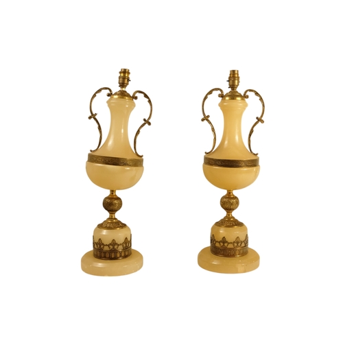 42 - A pair of alabaster and gilt metal table lamps - with twin handles and foliate castings, 58cm high. ... 