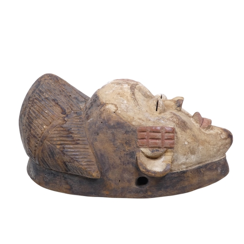 69 - A carved hardwood African mask - polychrome painted with a white face and terracotta flashes, 30cm h... 