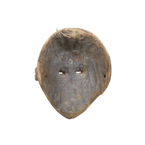 70 - A carved hardwood African mask - dark stained and decorated with white disks, 28cm high