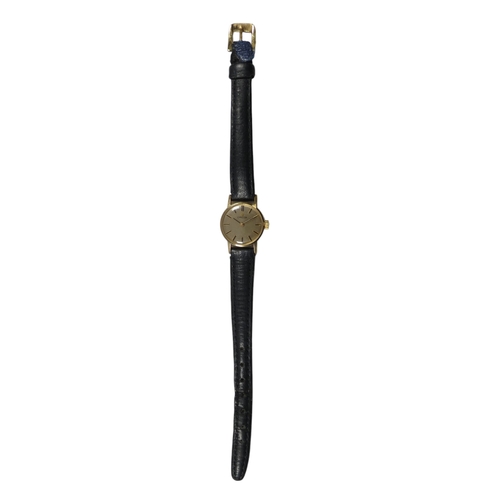 703 - A 9ct ladies Omega wristwatch - the gilt dial set out with batons, on a black leather strap with bra... 