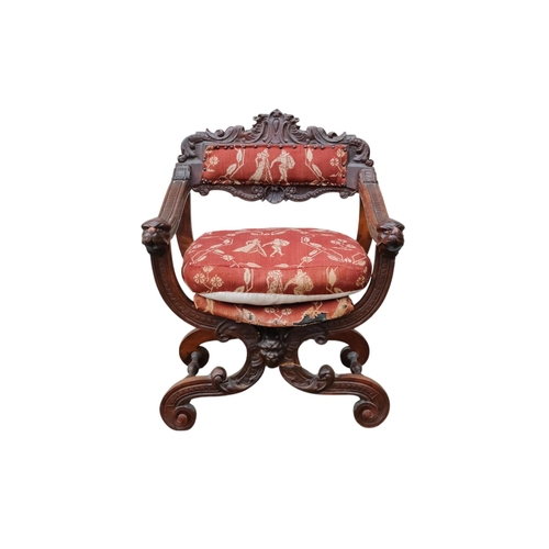 922 - A 17th century style continental walnut Savonarola chair - with carved lion mask finials.