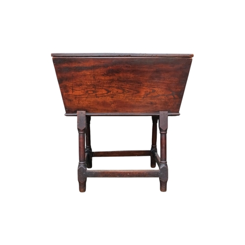 923 - An 18th century elm dough bin - of typical tapering rectangular form and raised on square and turned... 