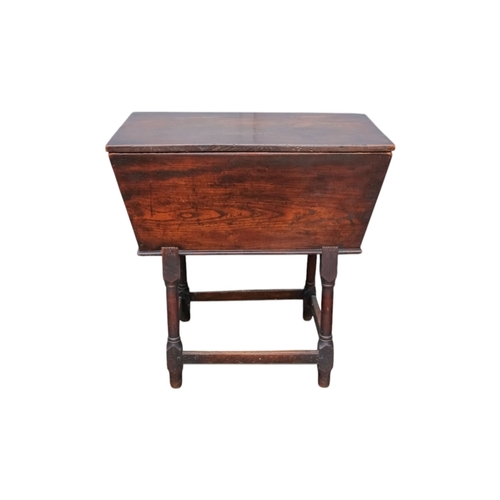 923 - An 18th century elm dough bin - of typical tapering rectangular form and raised on square and turned... 