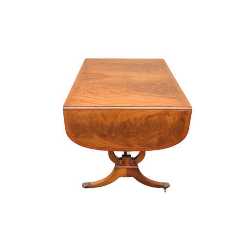 931 - A George III sytle mahogany sofa table - the rectangular top with drop ends, on lyre shaped end supp... 