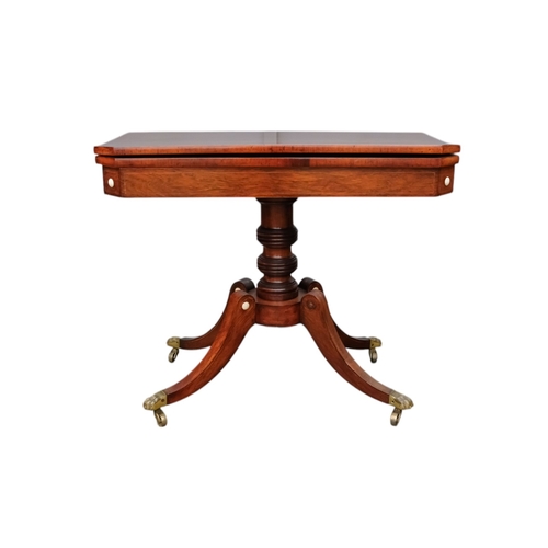 934 - A George IV rosewood card table - the rectangular top with canted corners, on a turned support and p... 