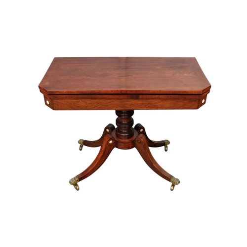 934 - A George IV rosewood card table - the rectangular top with canted corners, on a turned support and p... 