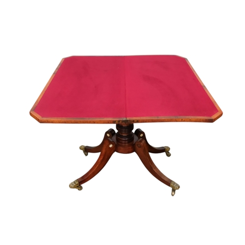 934 - A George IV rosewood card table - the rectangular top with canted corners, on a turned support and p... 