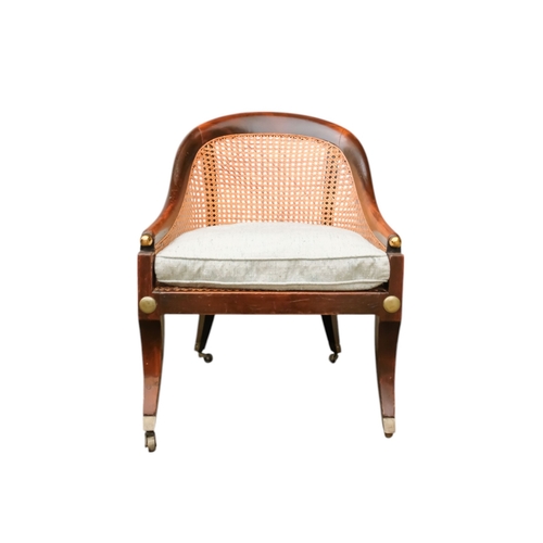 935 - A 19th century beech tub shaped bergere chair - with cane seat and back with a loose cushion, on squ... 