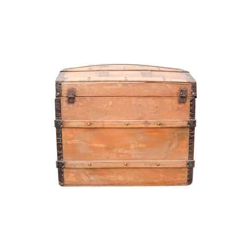 936 - An early 20th century beech and iron bound trunk - with a domed lid and laths, including iron fittin... 